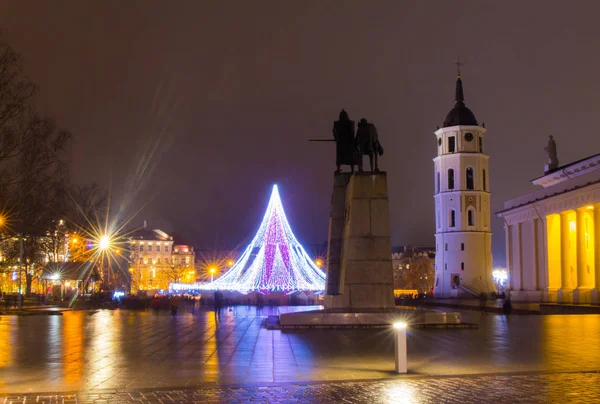 VILNIUS, LITUÂNIA - DEZEMBRO 31 2017: visão noturna da árvore de Natal na praça central, no campanário e na Catedral de Santo Estanislau e de São Vladislau na véspera dos novos anos . — Fotografia de Stock