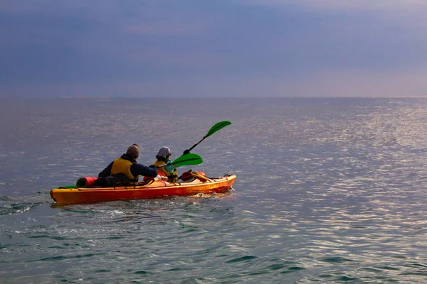 Sportler Kajakfahrer Mann und Frau gehen auf eine Kajakfahrt in der Bucht des Schwarzen Meeres, um der schönen Morgendämmerung zu begegnen. Erstaunliche Aussichten. perfekte Aktivität für den Urlaub. die Halbinsel Krim, Russland, Ukraine. — Stockfoto