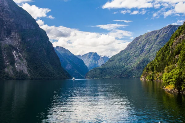 Scenic landscape View on the mountain peaks with green slopes and surface of water and feather clouds on the sky on background in sunny day. Neroyfjord - the narrowest fjord in Norway, Gudvangen Flam — Stock Photo, Image