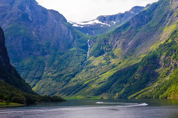 Paisagem cênica Vista sobre os picos da montanha com encostas verdes e superfície de água e nuvens de penas no céu no fundo em dia ensolarado. Neroyfjord - o fiorde mais estreito da Noruega, Gudvangen Flam — Fotografia de Stock