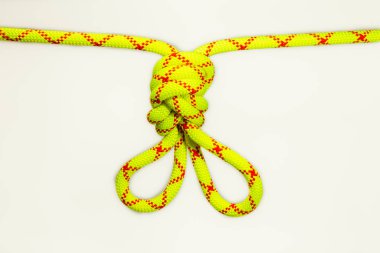 Sekiz düğümlü çift figür ya da Flaman ilmeği ya da dağcılıktaki çapaları yükseltmek ya da eşitlemek için tavşan kulağı kullanılır. Esnek renkli, kişisel bağlama için yeşil ip. Beyaz arkaplanda izole.