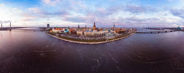 Luchtpanoramisch uitzicht op histirisch centrum Riga, kade van de rivier Daugava. Beroemde oriëntatiepunt - St. Peters Kerken toren en City Dome Cathedral kerk, Old Town Monument. Letland, Europa. schot van drone — Stockfoto