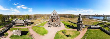Beautiful Aerial view to traditional Russian village with orthodox wooden chapel and bell tower in Bogoslovka manor. Pokrovskaya multi domed church holy virgin in Easter day. St. Petersburg, Russia. clipart