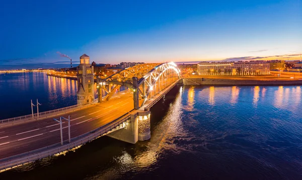 Санкт-Петербург Росія. Повітряний панорамний вид з дрону на міст Петра Великого білої ночі. Більшоктінський міст через річку Неву з вечірнім освітленням міста з водіння автомобілів на автостраді. — стокове фото