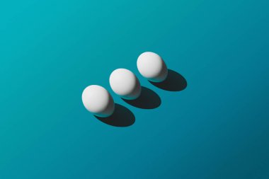 Mavi arka plan, Paskalya desen üstten görünüm beyaz tavuk yumurta. Metin, yatay görüntü için yer ile minimal tasarım.