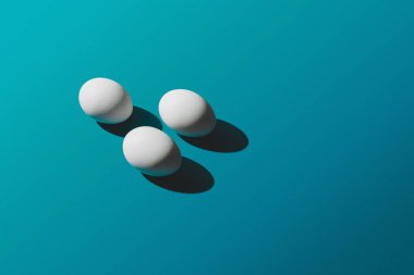 Mavi arka plan, Paskalya desen üstten görünüm beyaz tavuk yumurta. Metin, yatay görüntü için yer ile minimal tasarım.