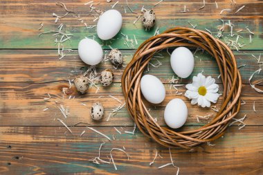 Paskalya yumurta üzerinde ahşap arka plan, üstten görünüm alanı kopyalayın. Paskalya natürmort. Paskalya dekor. Bıldırcın yumurta bir yuvaya boşaltmak metin tebrik için ahşap tablo.