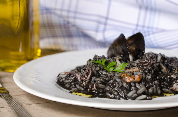 Black risotto plate with seafood.