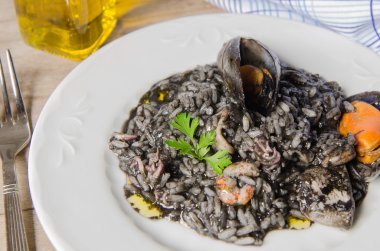 Deniz ürünleri ile siyah risotto plaka.