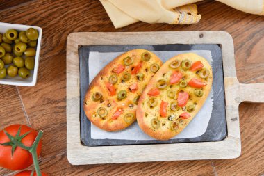 Değişik Focaccia çeşitleri, kabaklı, havuçlu ve pancarlı, rustik bir masada. Domatesli, zeytinli ve biberiyeli geleneksel İtalyan ekmeği.