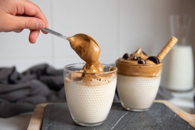 Dalgona kahvesi - Şeker ve sıcak suyla çırpılmış kahve veya espresso tozu. Buzlu, çırpılmış, dalgona kahve konsepti.