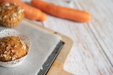 Elmalı, havuçlu ve fındıklı tam tahıllı kekler, arka planda kırsal kesim tahtası, sağlıklı vejetaryen yiyecekler, sütsüz süt ürünleri.