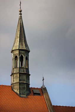gökyüzüne karşı kırmızı çatılı bir kilisenin kulesi. Krakow, Polonya Mimarisi