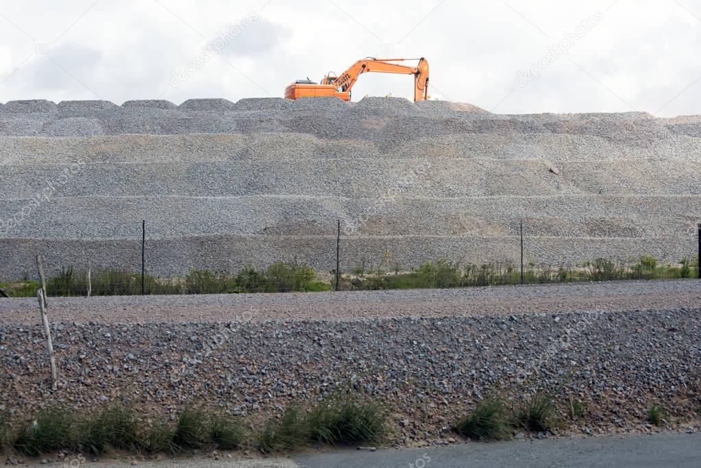 Excavator on hill of material