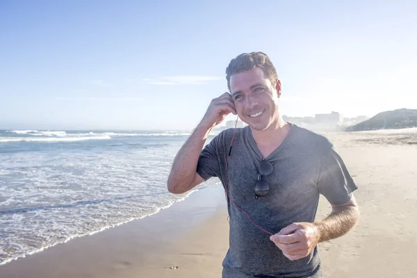 Man op strand met koptelefoon — Stockfoto