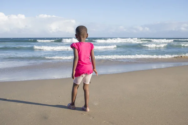 Mała dziewczynka w kolorze różowym na plaży — Zdjęcie stockowe