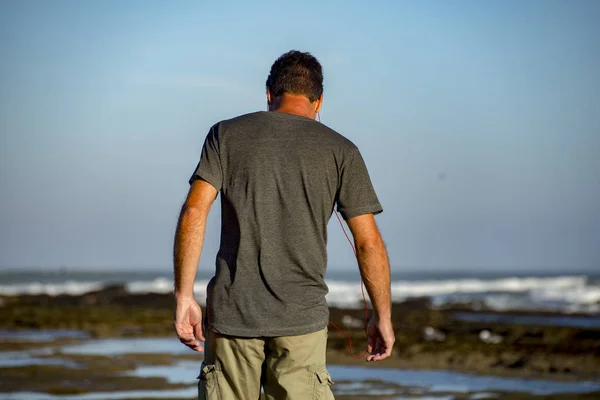 Hombre en la playa junto a las rocas — Foto de Stock