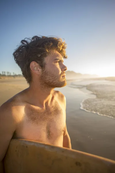 Portrait d'un surfeur avec planche sous le bras par l'océan — Photo