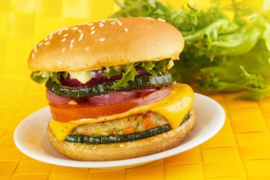 Sebzeli burger sebze patty, peynir ve kızarmış kabak, domates ve soğan ile