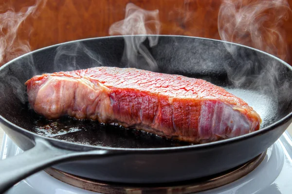 Sığır Eti Biftek Sıcak Dökme Demir Tava Ile Elektrikli Ocakta — Stok fotoğraf