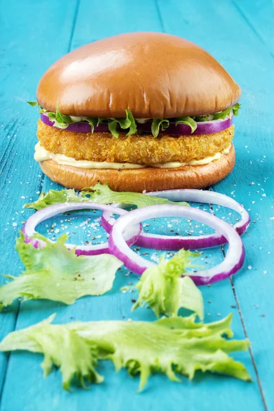 Hausgemachter Chicken Burger Mit Roten Zwiebelringen Und Salatblättern Auf Rustikalem Stockfoto
