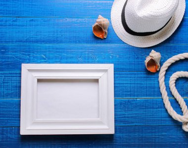 Moda şapka, deniz kıyısı ve mavi bir arka plan üzerinde beyaz bir çerçeve