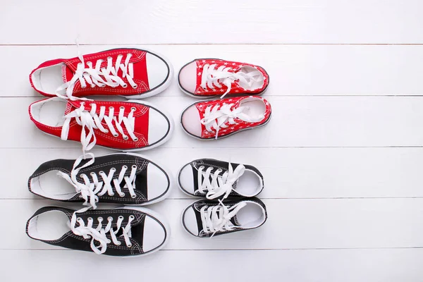 Moda. Sneakers per bambini e sneakers per adulti su sfondo bianco — Foto Stock