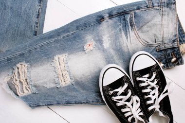 Beyaz bir arka plan üzerinde spor ayakkabıları ile moda kot pantolon