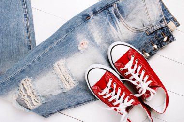 Beyaz bir arka plan üzerinde spor ayakkabıları ile moda kot pantolon