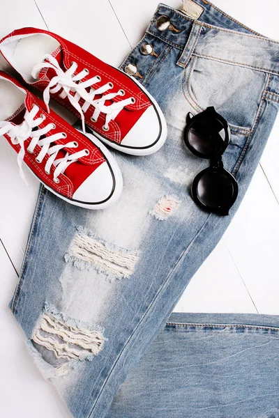 Jeans na moda com óculos de sol em um fundo branco — Fotografia de Stock