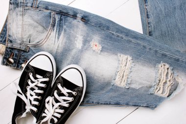 Beyaz bir arka plan üzerinde spor ayakkabıları ile moda kot pantolon