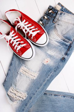 Beyaz bir arka plan üzerinde spor ayakkabıları ile moda kot pantolon