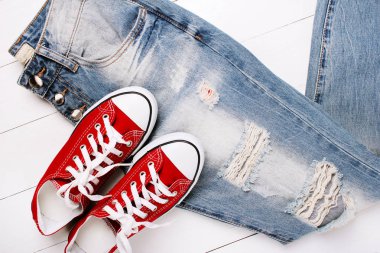 Beyaz bir arka plan üzerinde spor ayakkabıları ile moda kot pantolon