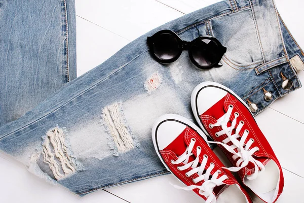 Jeans na moda com sapatilhas em um fundo branco — Fotografia de Stock