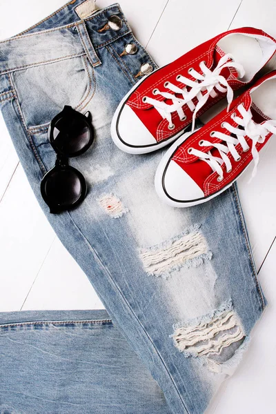 Jeans alla moda con scarpe da ginnastica su sfondo bianco — Foto Stock