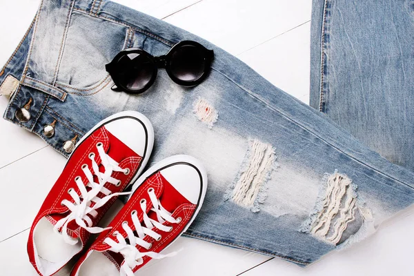 Fashionable jeans with sneakers on a white background — Stock Photo, Image