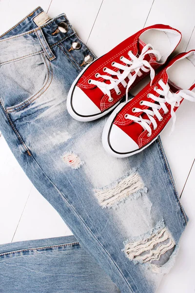 Jeans alla moda con scarpe da ginnastica su sfondo bianco — Foto Stock