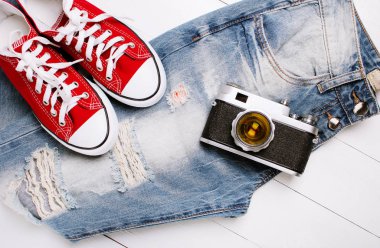 Beyaz bir arka plan üzerinde spor ayakkabıları ile moda kot pantolon