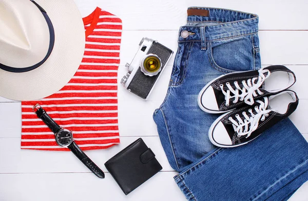 T-shirt elegante, jeans, câmera velha, chapéu e óculos de sol em um fundo branco — Fotografia de Stock
