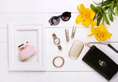 Beyaz bir çerçeve, lily çiçekler, ruj ve beyaz bir arka plan üzerinde güneş gözlüğü parfüm