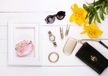 Beyaz bir çerçeve, lily çiçekler, ruj ve beyaz bir arka plan üzerinde güneş gözlüğü parfüm