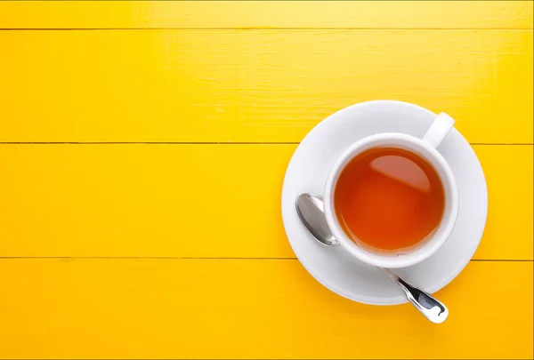 ถ้วยชาบนพื้นหลังสีเหลือง — ภาพถ่ายสต็อก