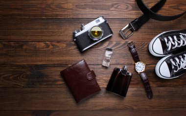moda. saat, cüzdan, kemer, Köln, spor ayakkabı ve ahşap arka plan üzerinde eski fotoğraf makinesi