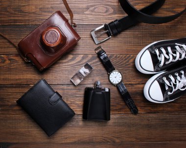 moda. saat, cüzdan, kemer, Köln, spor ayakkabı ve ahşap arka plan üzerinde eski fotoğraf makinesi
