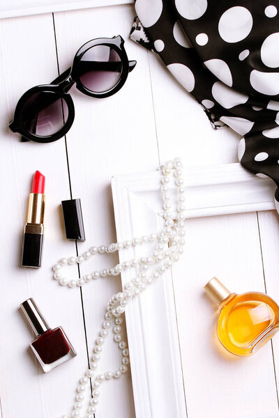 модный шарф, солнцезащитные очки, парфюмерия и жемчуг в белой рамке
