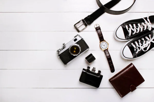 fashion. watches, wallets, belt, cologne, sneakers and old camera on a wooden background