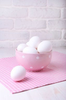 Beyaz bir masaya bir tabak içinde doğal yumurta