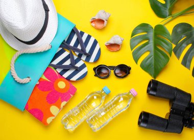 Sarı bir arka plan üzerinde şık plaj aksesuarları