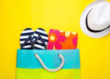 Sarı bir arka plan üzerinde şık plaj aksesuarları