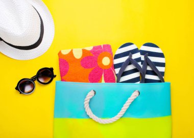 Sarı bir arka plan üzerinde şık plaj aksesuarları